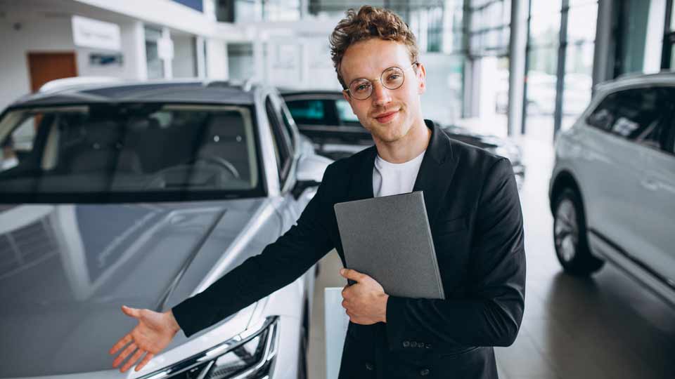 Ein Verkäufer zeigt auf ein Auto und erklärt dem Kunden die Konditionen beim Auto verkaufen Göppingen